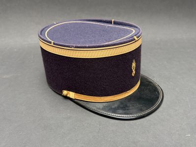 chapeau violet orné d'une bordure dorée, posé sur une surface grise