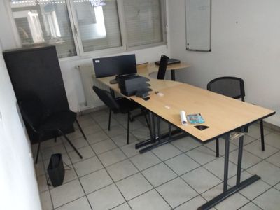 une pièce avec une table, deux chaises et un ordinateur portable posé dessus