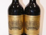 two bottles of red wine sitting next to each other on a table