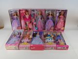 il y a beaucoup de poupées Barbie dans la boîte posée sur la table