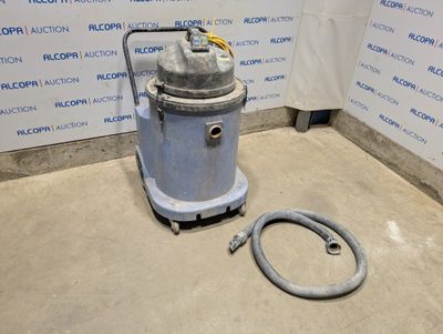 un aspirateur posé sur le sol à côté d'un tuyau
