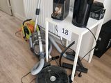 a picture of a room with a vacuum, coffee maker, and other household items
