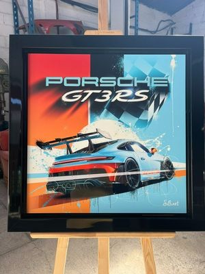 a framed picture of a porsche gt3 poster in a garage