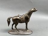 bronze statue of a horse on a base on a gray background