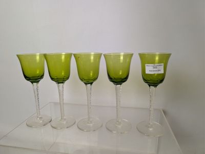 quatre verres à vin verts sont alignés sur une étagère transparente