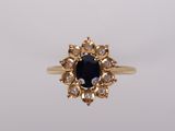 une bague en or sertie d'une pierre noire entourée de diamants blancs