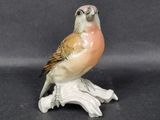 a small figurine of a bird sitting on a branch