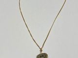 a gold necklace with a small evil eye on it