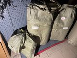 three bags of garbage sitting on a shelf next to a trash can