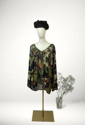 an image of a dress on a mannequin stand with a vase of flowers in the background