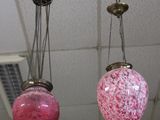 trois lampes roses suspendues au plafond dans une pièce