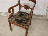 une chaise en bois dont l'assise est recouverte d'un tissu noir et marron