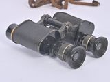 an old pair of binoculars sitting on top of a white surface