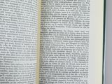 an open book on a table with a pen in it