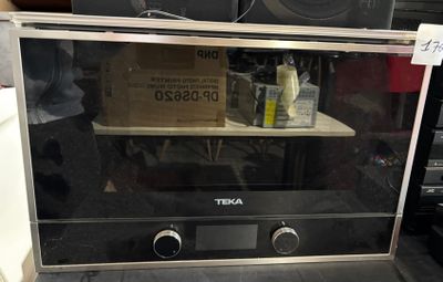 a microwave that is sitting on a shelf in the kitchen
