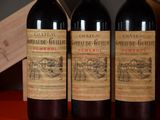 three bottles of red wine are lined up on a table