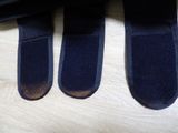 three pairs of black socks that are on a table
