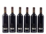 six bottles of wine are lined up in a row on a white surface