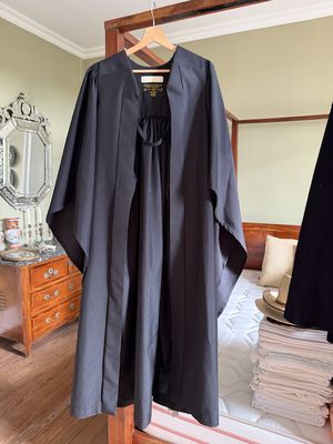 une robe noire posée sur un lit dans une chambre