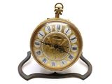 une horloge dorée à chiffres romains posée sur un socle