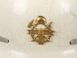 a white helmet with a gold emblem on it