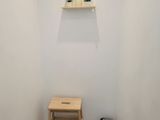 a small wooden step stool in the corner of a small room