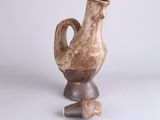a small vase with a broken handle on a table