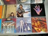 a lot of music cds on a table with a guitar