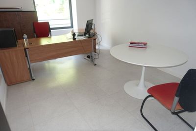 une table et des chaises dans une pièce équipée d'un bureau et d'une télévision