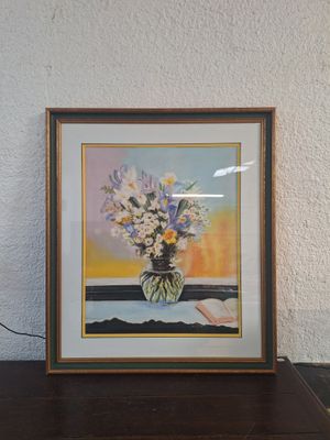 tableau représentant des fleurs dans un vase posé sur une table près d'un mur