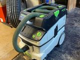 une photo d'un aspirateur vert et noir posé par terre