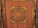 une écharpe orange, noire et bleue, ornée d'un motif carré