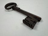 an old key is sitting on top of a wooden block