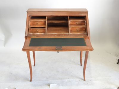 un petit bureau en bois avec un plateau noir et des tiroirs