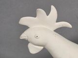 a white sculpture of a bird on a gray surface