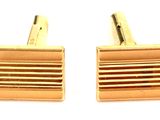 deux paires de boutons de manchette en or sur fond blanc
