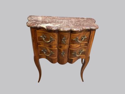 a small marble top chest of drawers on a stand