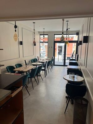 Dans un restaurant donnant sur la rue, les tables et les chaises sont alignées.