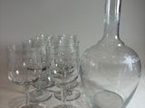 many wine glasses and a decanter sitting on a table