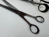two pairs of scissors sitting on a table next to each other