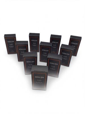six boxes of black perfume sitting on top of a white surface