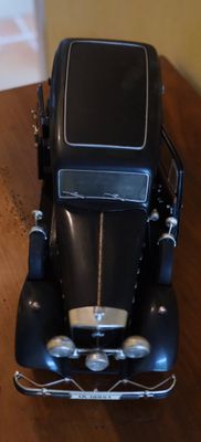 une petite voiture noire posée sur une table en bois