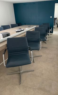 une longue table avec quatre chaises devant