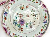 two plates with flowers on them on a white table