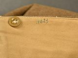 a close up of the bottom of a tan bag with a button on it