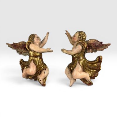 une paire de figurines d'anges posées sur une surface blanche, avec un fond blanc