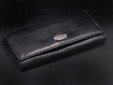 un portefeuille en cuir noir posé sur une surface noire
