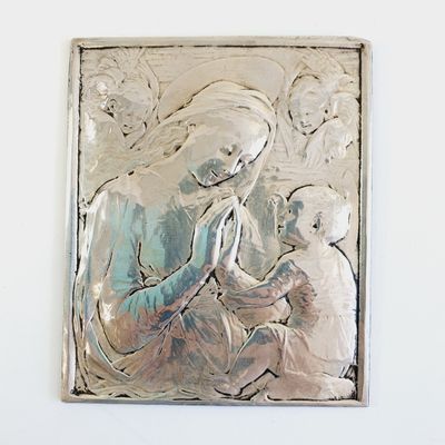 a silver plaque with a picture of a woman holding a child