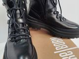 pair of black leather boots sitting on top of a cardboard box