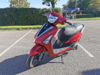 a red scooter that is parked in a parking lot